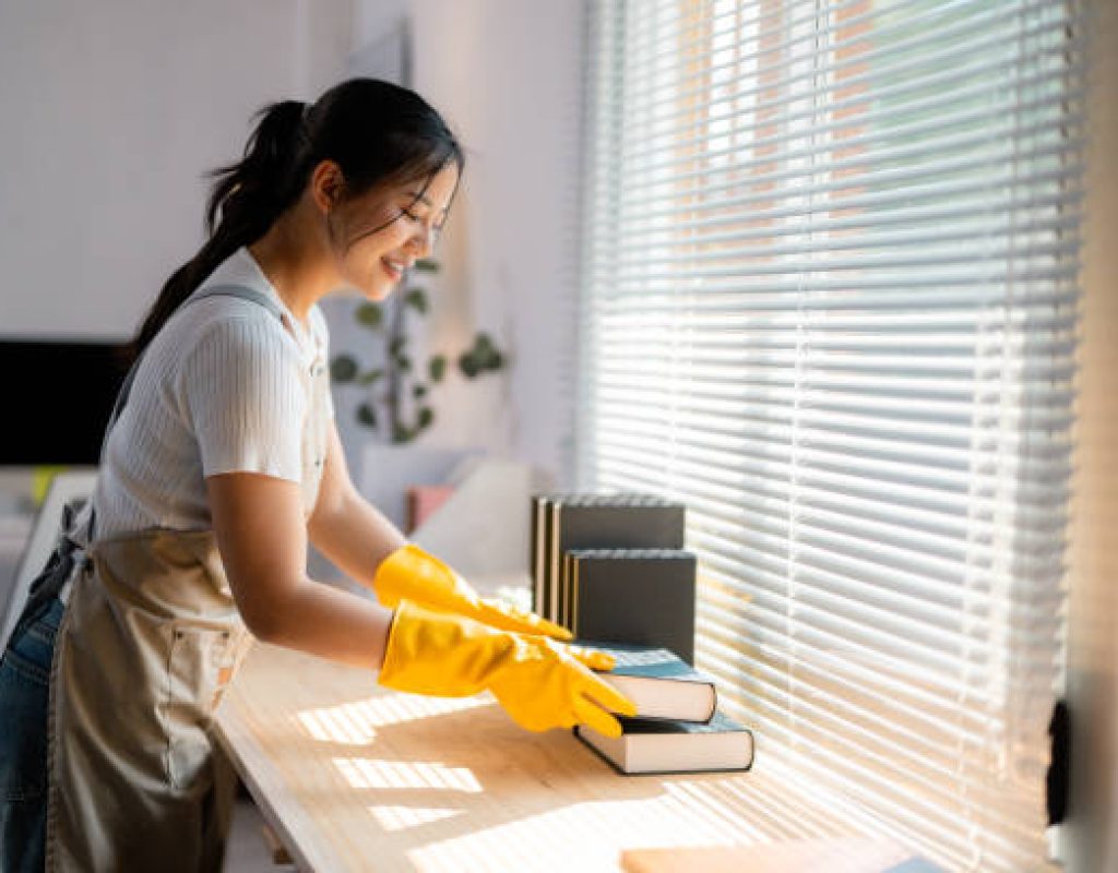 Two professional maids cleaning a bright kitchen in a modern Herriman, UT home with family photos visible